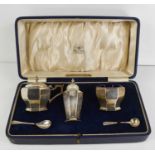 A silver cruet set by Mappin & Webb, comprising salt, pepper, mustard pot, and having blue glass