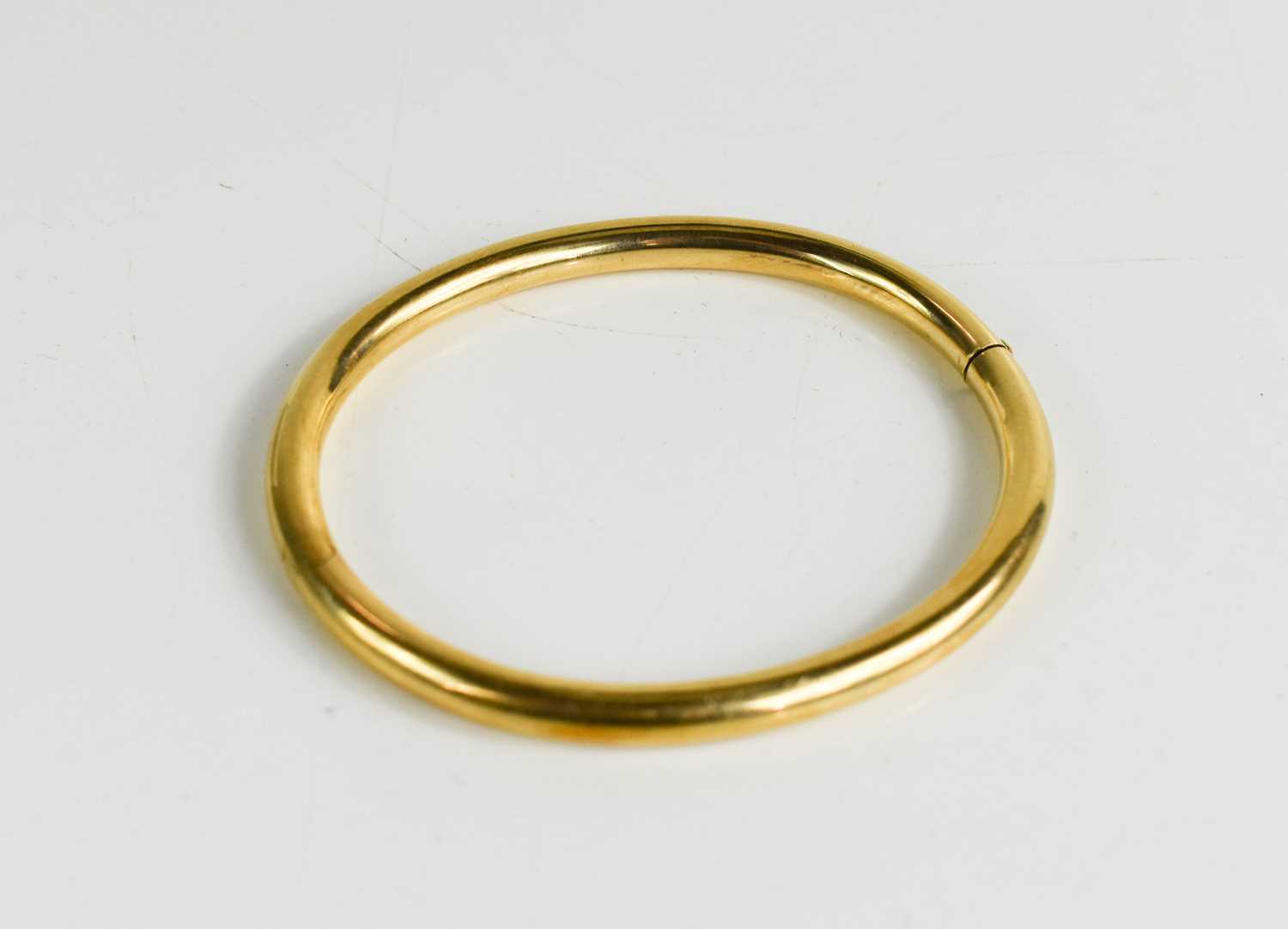 A 14ct gold bangle, with hinged clasp, 13.50g, internal measurements 52.6 by 60.4mm.