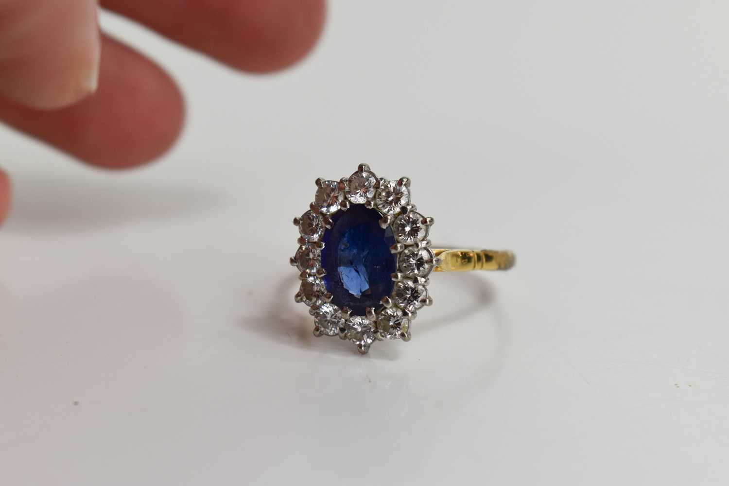 An 18ct gold, sapphire and diamond, flowerhead ring, the oval cut deep cornflower blue stone of - Image 6 of 6