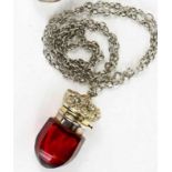 A Victorian acorn form vinaigrette, circa 1890, in red glass and gilt interior with metal chain.