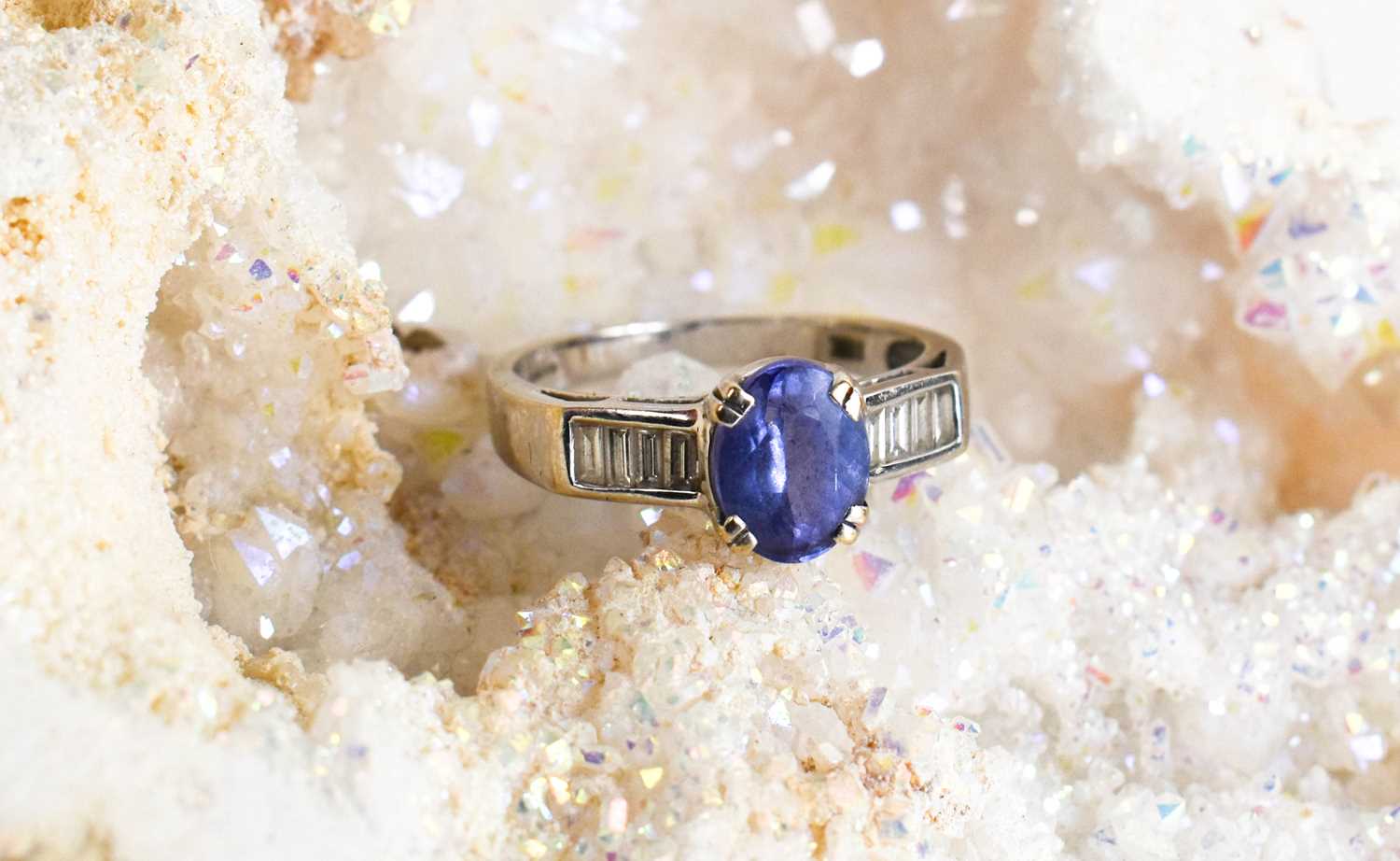 An 18ct white gold, tanzanite and diamond ring, the oval cut tanzanite flanked by baguette cut - Image 4 of 4