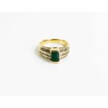 A gold (testing as at least 9ct), diamond and emerald ring, the rectangular cut emerald flanked by