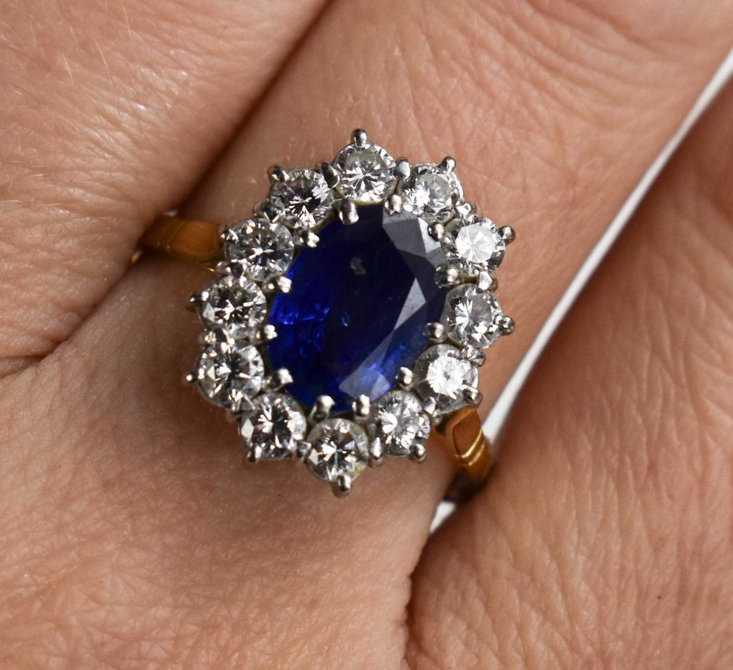 An 18ct gold, sapphire and diamond, flowerhead ring, the oval cut deep cornflower blue stone of - Image 5 of 6