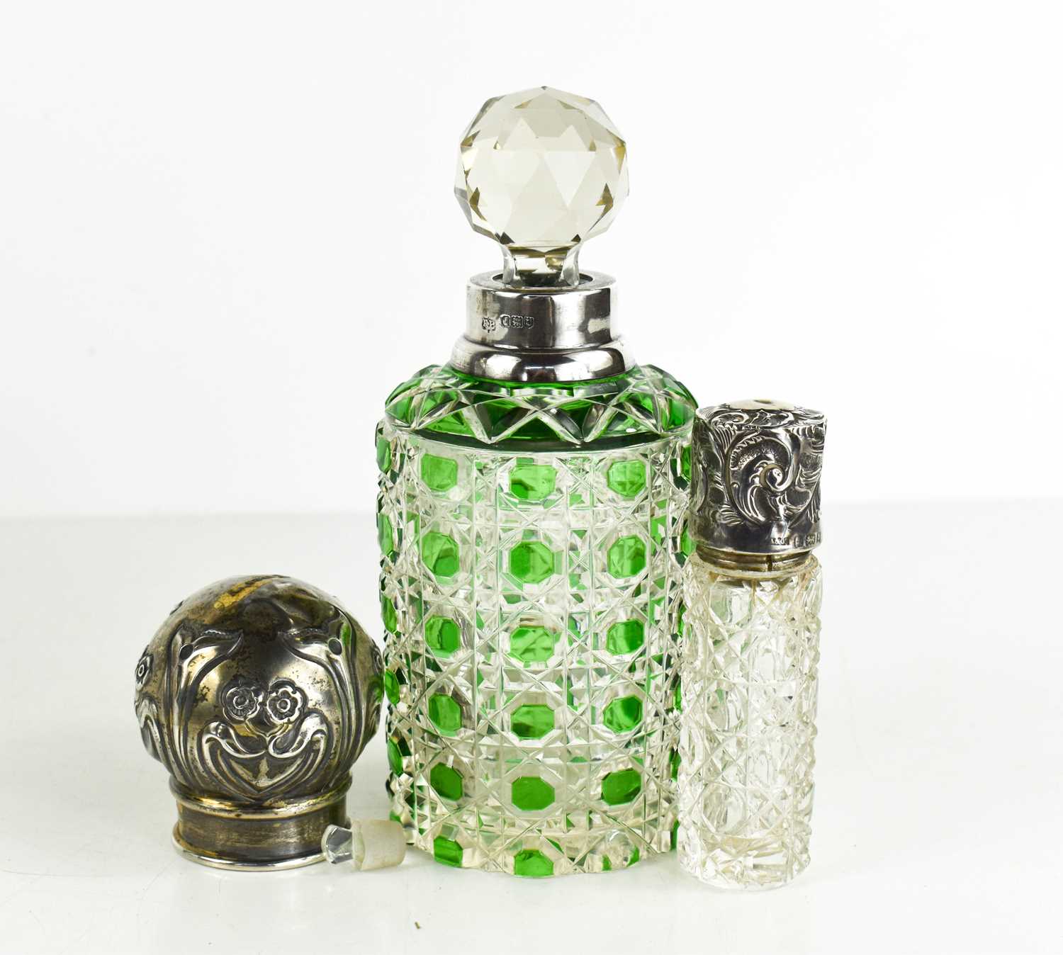 A silver and cut glass scent bottle with green overlay, a smaller screw top silver scent bottle, a