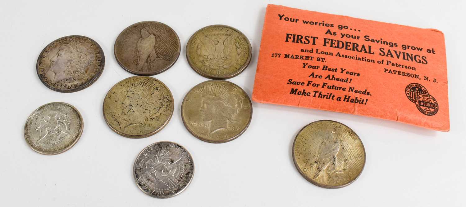 A group of silver dollars and half dollars, dating from 1889 to 1968.