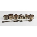 Four silver napkin rings together with an Edwardian silver fork, two white metal napkin rings and