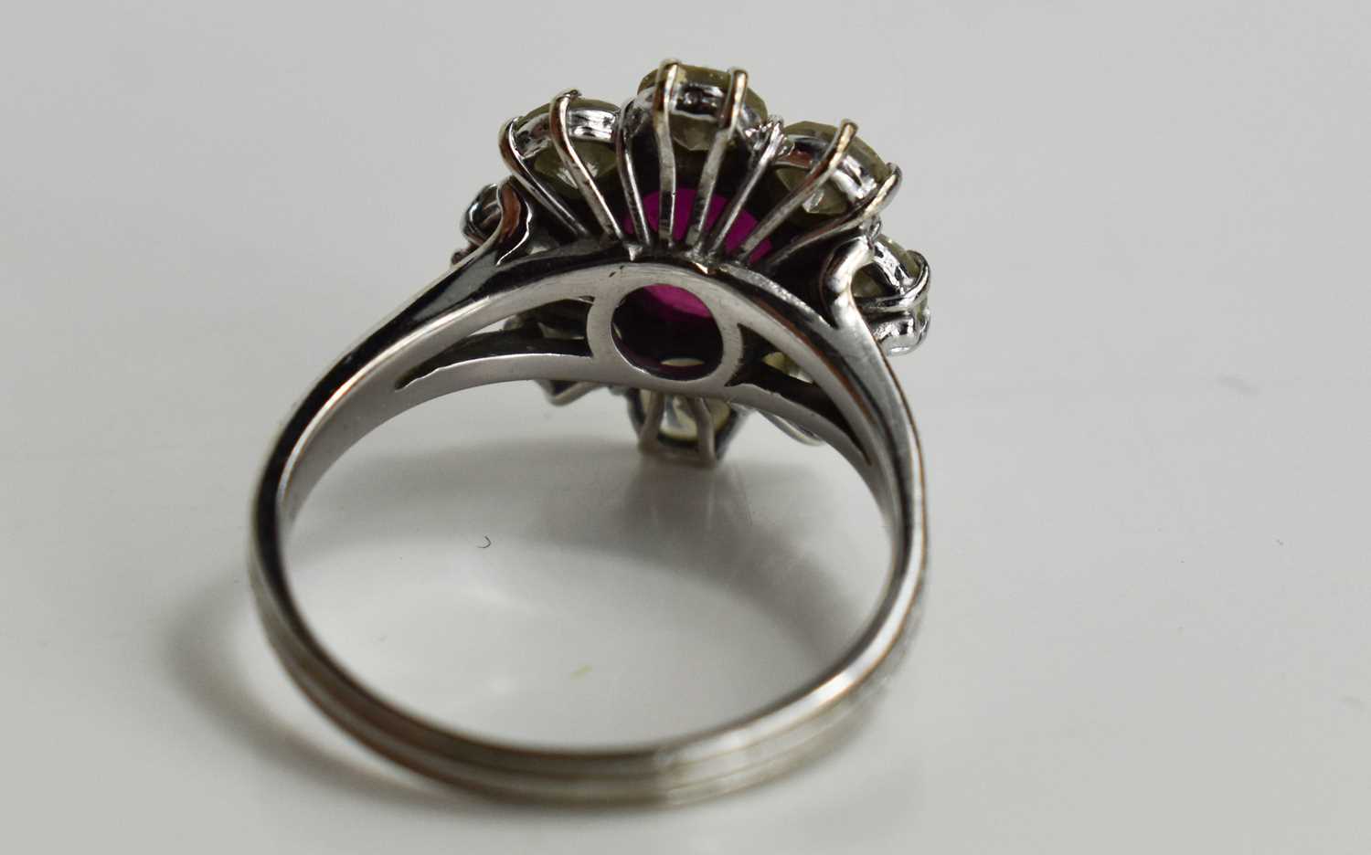 An 18ct white gold, (unmarked but tested as 18ct) ruby and diamond flowerhead ring, the central oval - Image 5 of 11