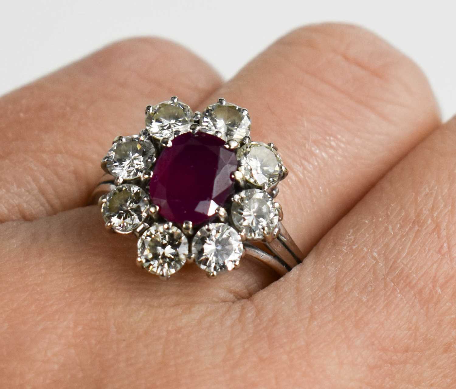 An 18ct white gold, (unmarked but tested as 18ct) ruby and diamond flowerhead ring, the central oval - Image 2 of 11