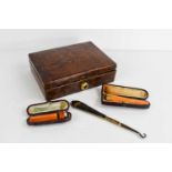 An early 20th century crocodile skin jewellery box together with two amber cheroot holders, one with