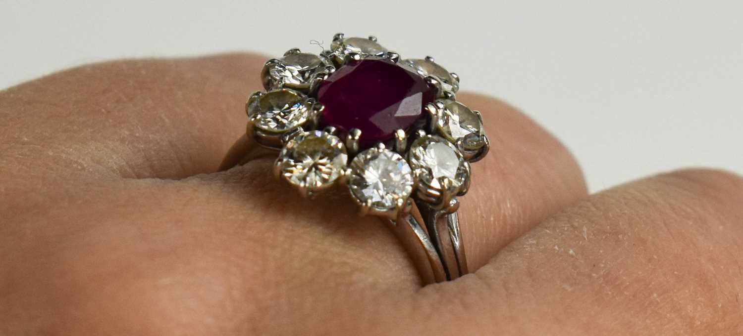 An 18ct white gold, (unmarked but tested as 18ct) ruby and diamond flowerhead ring, the central oval - Image 3 of 11