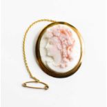 A Victorian cameo brooch, in a gold (tested as 9ct) setting, with safety chain, the female profile