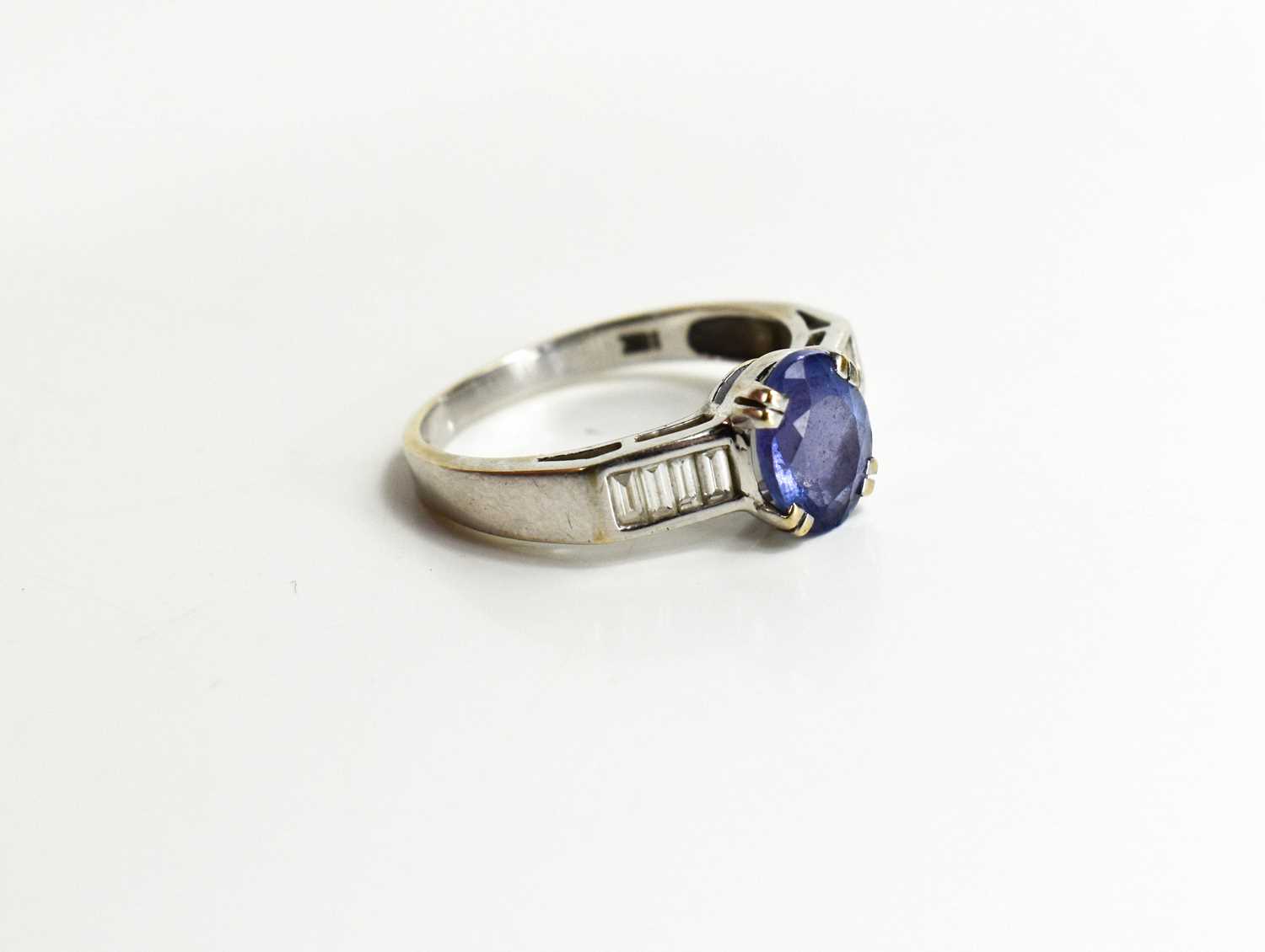 An 18ct white gold, tanzanite and diamond ring, the oval cut tanzanite flanked by baguette cut - Image 3 of 4