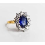 An 18ct gold, sapphire and diamond, flowerhead ring, the oval cut deep cornflower blue stone of