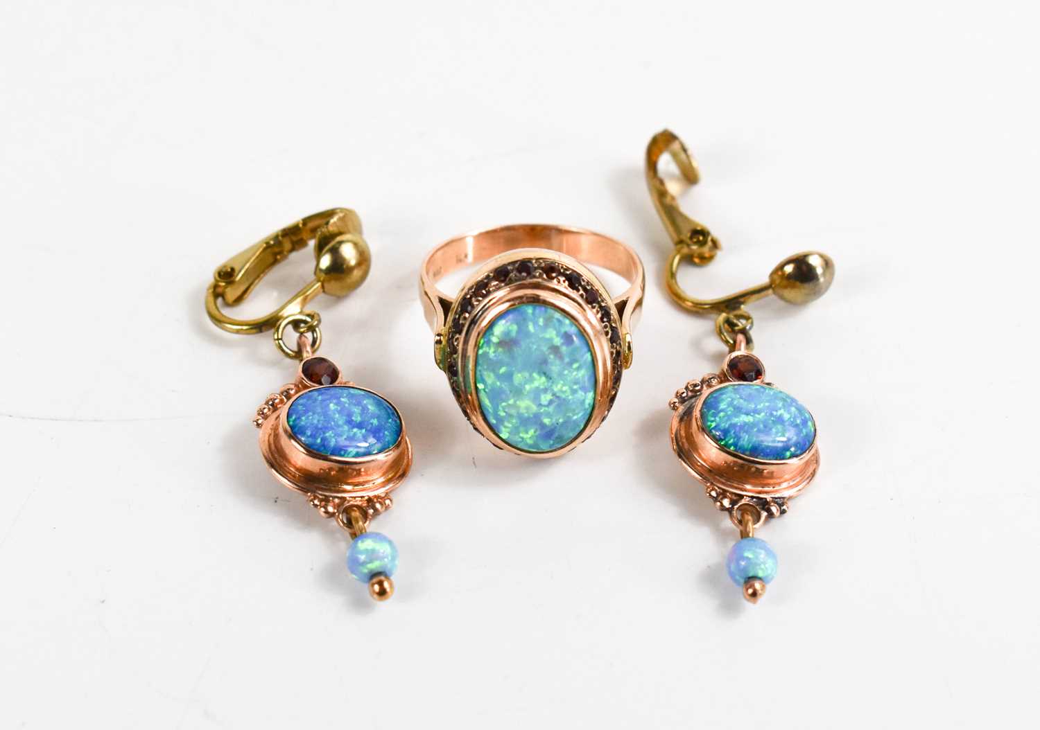 A 14ct gold, black opal and garnet ring, size O, 7.3g, and a pair of matching drops, set on base