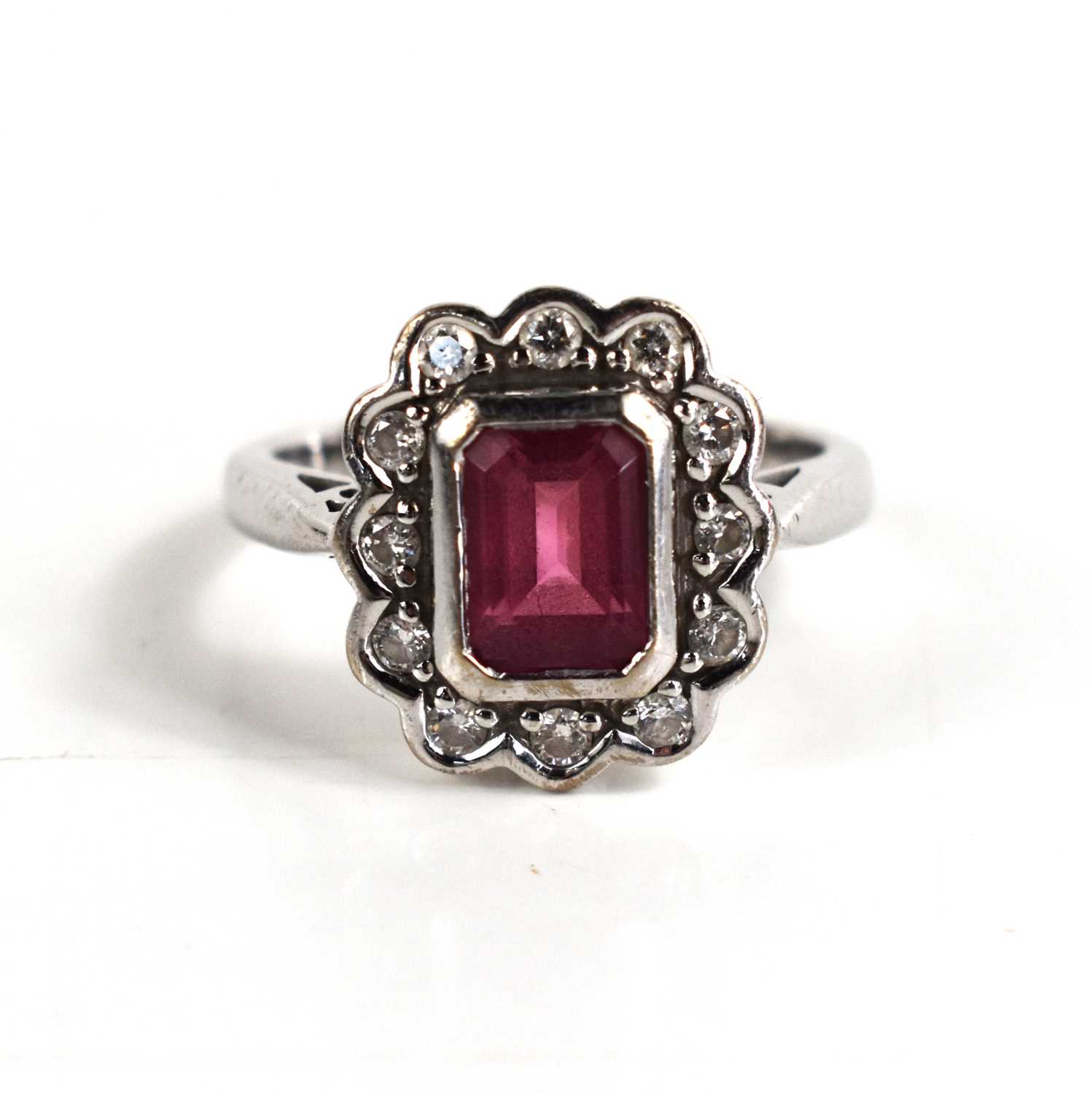 An 18ct with gold, pink tourmaline and diamond dress ring, the central emerald cut tourmaline of