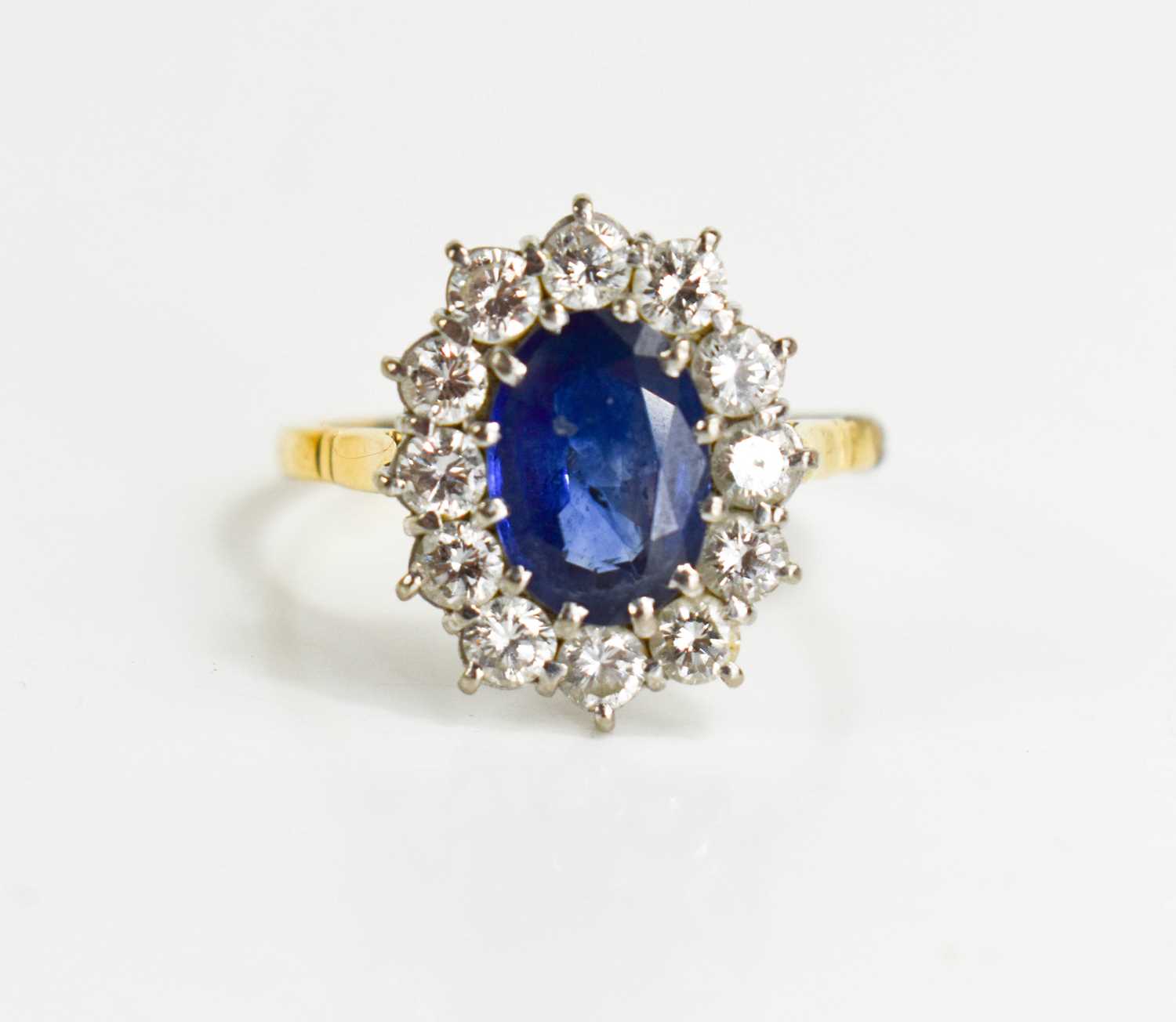 An 18ct gold, sapphire and diamond, flowerhead ring, the oval cut deep cornflower blue stone of - Image 2 of 6