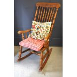A 19th century American elm spindle back rocking armchair with slab seat and turned legs with two