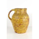 A 19th century glazed earthenware jug, the body with written verse incised into the glaze, dated