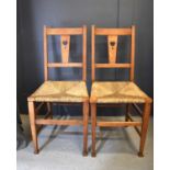 A pair of Shaker style oak chairs, circa 1920, the splats with pierced heart motifs and raised on