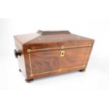 A 19th century mahogany tea caddy with brass inlaid decoration, interior lids, glass bowl, and