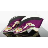 A pair of Chinese silk lotus shoes, circa 1920, the purple silk embroidered to depict butterflies,