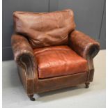 A vintage leather armchair with studwork, raised on turned legs with castors.