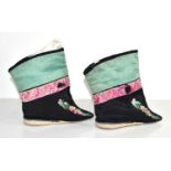 A pair of Chinese lotus shoes with ankle wrappers, in green, pink and black silk, embroidered with