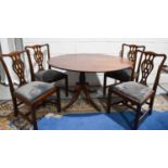 A Georgian mahogany tilt top oval dining table, raised on a baluster turned column, over four out