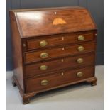 An Edwardian bureau, the full front enclosing an interior fitted with pigeon holes and drawers,