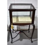A mahogany glass display cabinet on stand, the bevelled glass door enclosing a single shelf