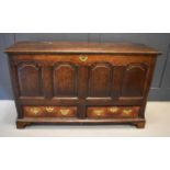 An 18th century oak mule chest with four fielded panels and two drawers, raised on bracket feet,