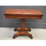 A mahogany fold over card table, with green baize inside the top, raised on a pedestal triform base,