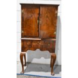 A 17th century style walnut cabinet on stand, the two doors above three drawers, raised on