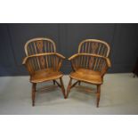 A pair of elm windsor armchairs with hoop back, bowed arm rail pierced with spindles, raised on