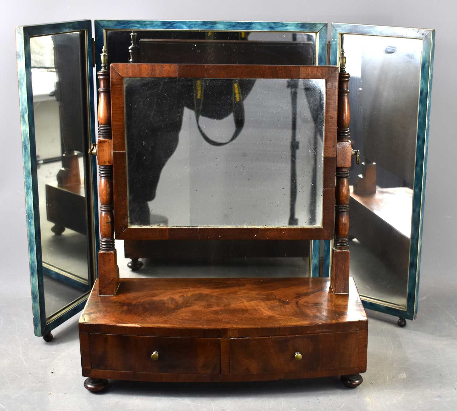 A 19th century bow fronted mahogany toilet mirror, the vertical supports terminating in