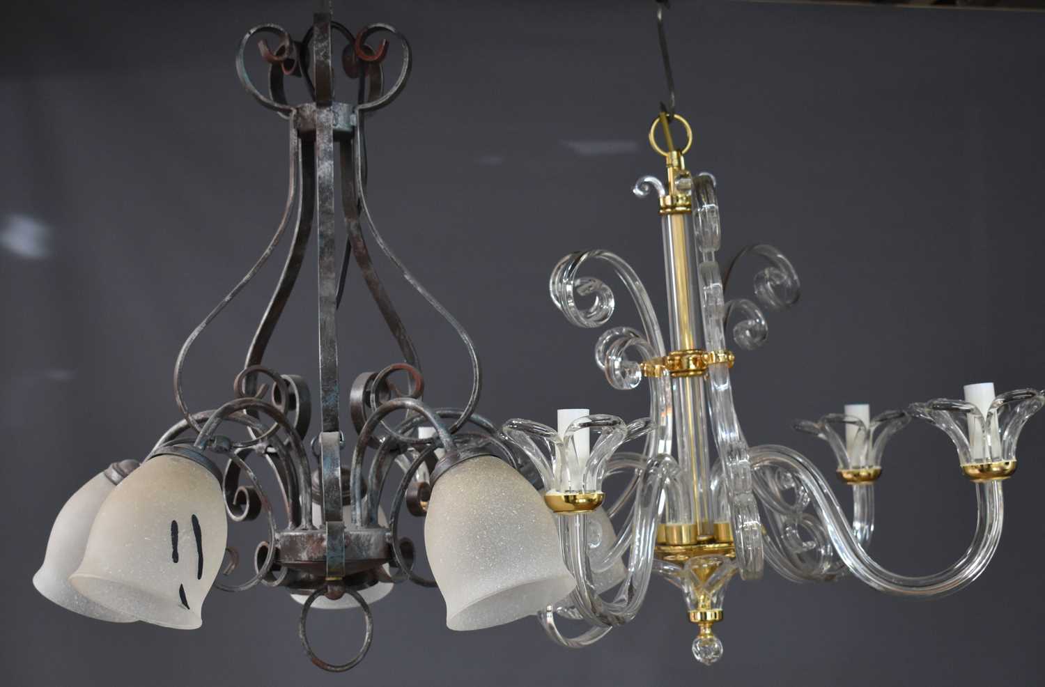 A metal chandelier with five lights having opaque glass shades, together with a glass scrollwork