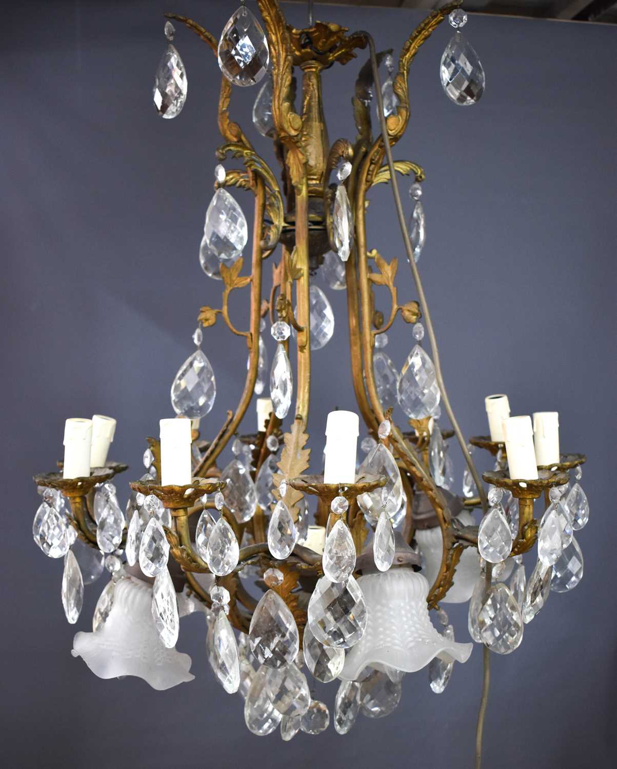 An antique French gilt brass and cut glass chandelier, the twin branches raising ten candle bulb