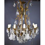 An antique French gilt brass and cut glass chandelier, the twin branches raising ten candle bulb