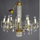 A glass and gilt metal nine branch chandelier, each of the scroll branches with three sprigs holding