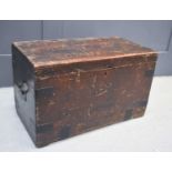 An antique stained pine travelling chest, with paper lined interior and two iron handles.