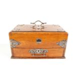 An Edwardian oak smokers compendium, with sliding top and drawer, with compartments throughout,