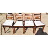 A set of four Edwardian dining chairs with cream upholstered seats.