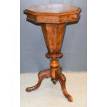 A Victorian octagonal work table with fitted interior, paper lined pedestal box and raised on
