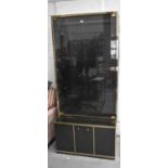 A black and gold coloured, late 20th century design bookcase, the top with smoked glass doors,