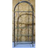 A tubular steel and glass arched book case, with brushed steel effect body and bright brass corners,