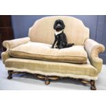 A French walnut framed camel back settee, upholstered in velvet with tassel trim, the frame having