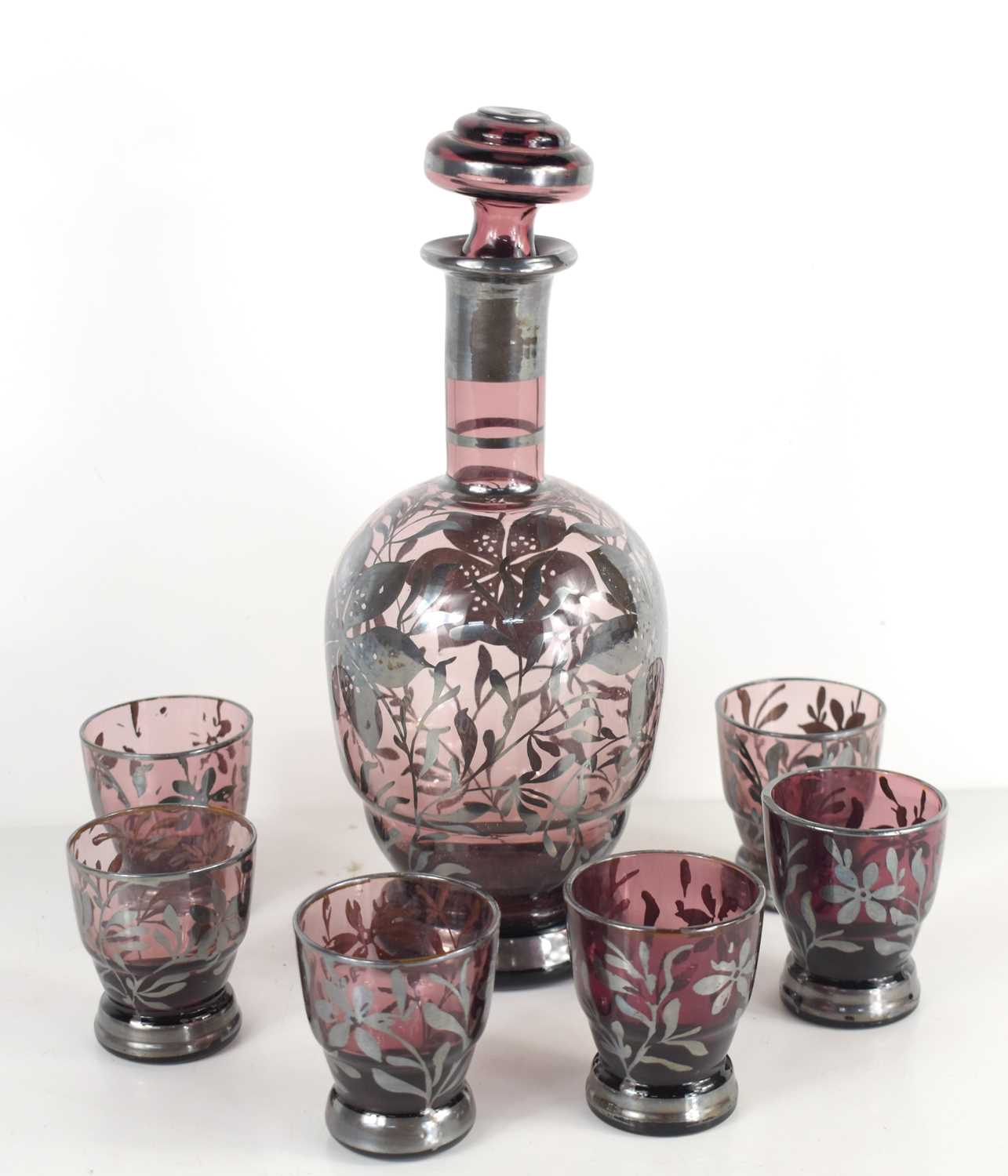 A set of six 19th century amethyst liqueur glasses and decanter, each derated with silver coloured