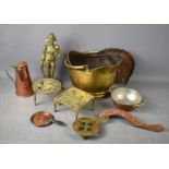 A group of copper and brass wares, comprising a helmet coal scuttle, a brass door stop, modelled
