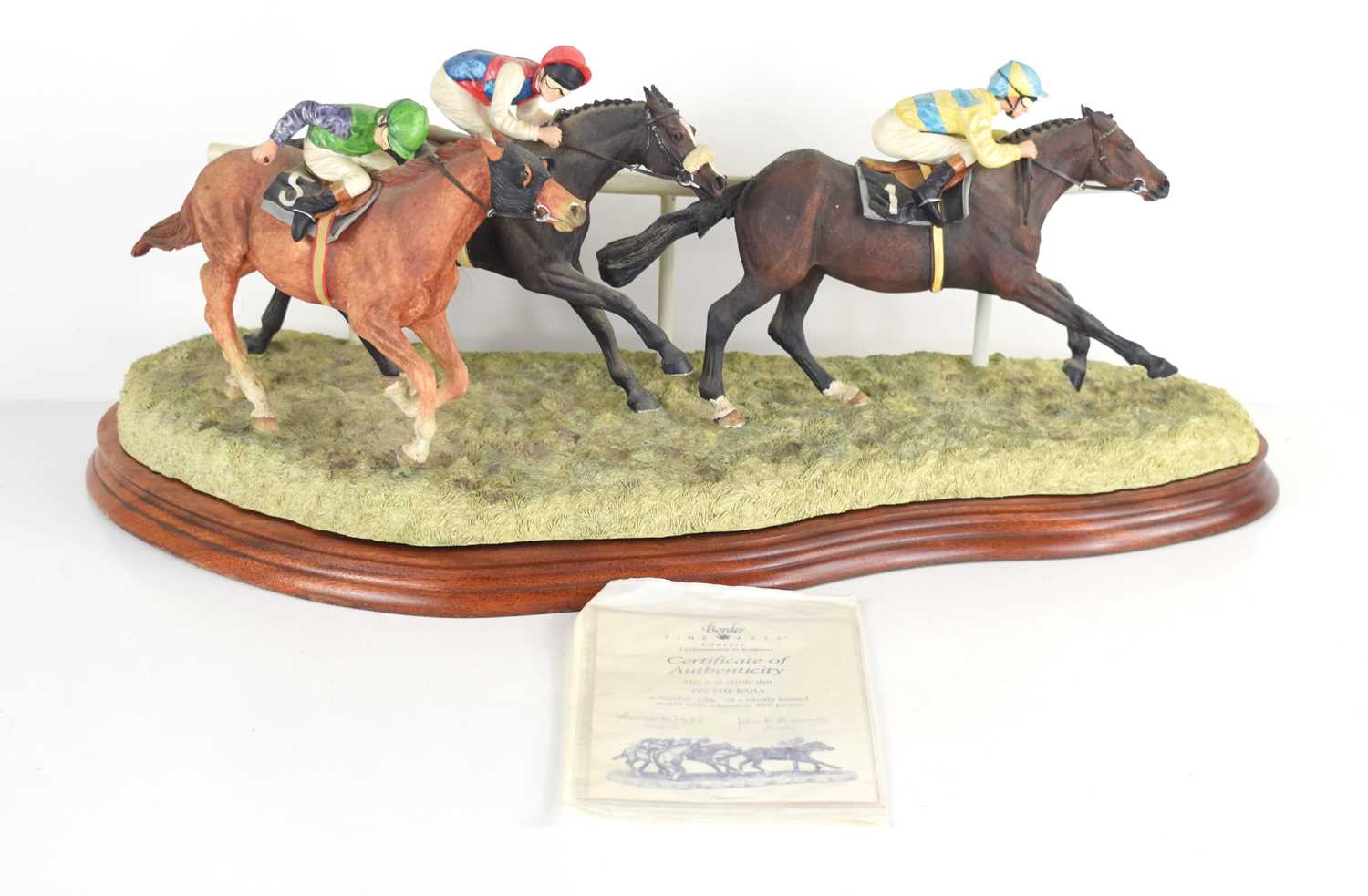 A Border Fine Arts horse racing sculpture "On the Rails" by Anne Wall, raised on a wooden plinth,