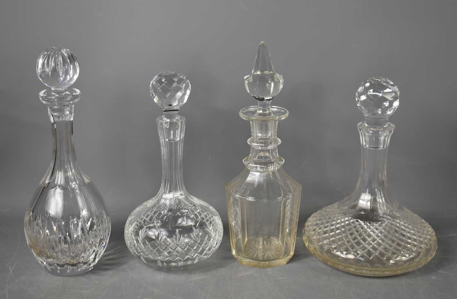 A group of four cut glass decanters, including a Victorian example.